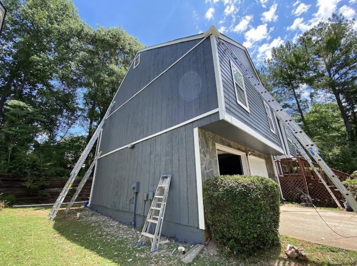 Full exterior repaint on barn-style two-story Atlanta home, ladders staged