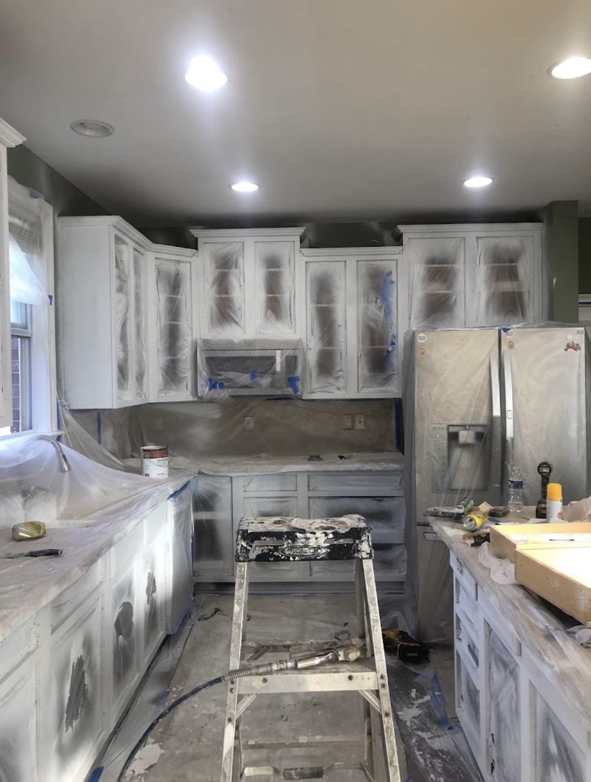 Kitchen cabinet refinish in progress with spray masking by Pine Peach Painting